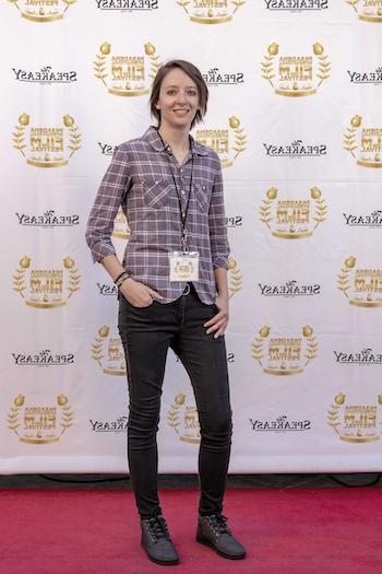 Ashley Seering in black jeans and a flannel shirt on the Red Carpet at the Passadena Film Festival.